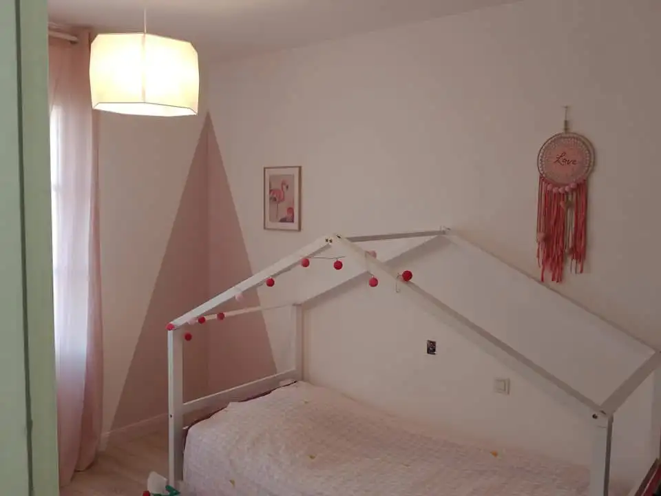 Chambre rose poudré réalisée par Atelier Nuance